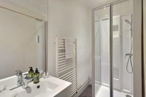 a white bathroom with a sink and a shower at Le Village - Appart Terrasse Proche gare in Sainte-Savine