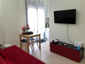 - un salon avec un lit, une table et une télévision dans l'établissement Lamia central luxury apartment, à Lamía
