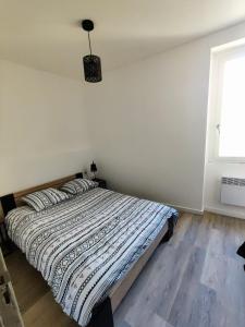 een slaapkamer met een bed in een kamer met een raam bij Appart T3 à Pamiers in Pamiers