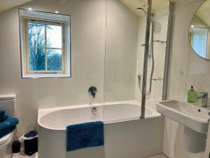 a bathroom with a shower and a tub and a sink at Helm Mount Lodge & Cottages in Kendal