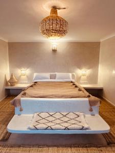 Un dormitorio con una cama grande y una lámpara de araña. en Amazigh Home en Mirleft