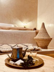 ein Tee-Set auf einem Tisch in einem Schlafzimmer mit einem Bett in der Unterkunft Amazigh Home in Mirleft