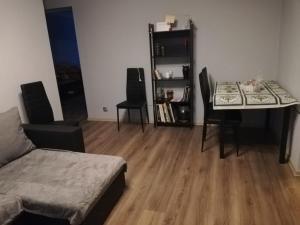 uma sala de estar com uma mesa e cadeiras e um sofá em Saknes apartamenti em Riga