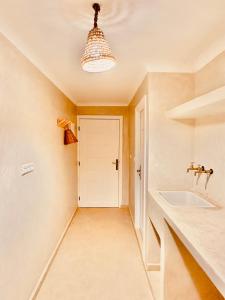 a bathroom with a sink and a white door at Amazigh Home in Mirleft +18 photos