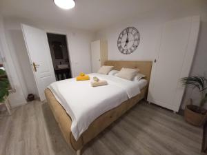 a bedroom with a large bed with a clock on the wall at Studio apartman Singer in Vrbovsko