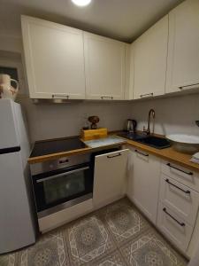 a kitchen with white cabinets and a stove top oven at Studio apartman Singer in Vrbovsko