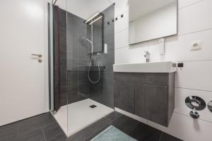 a bathroom with a shower and a sink at myQuartier Innsbruck City Apartments in Innsbruck