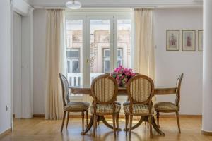 a dining room table with chairs and a vase of flowers at The Avant Garde in Athens