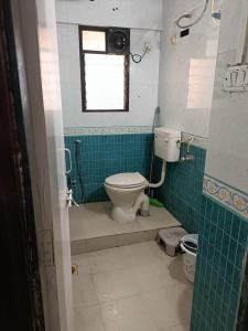a bathroom with a toilet and a window at Birds Nest in Pune