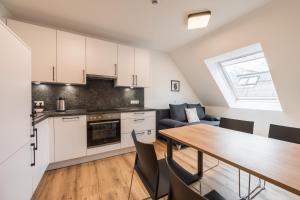 cocina y comedor con mesa de madera en myQuartier Innsbruck City Apartments en Innsbruck