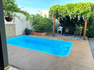 a blue swimming pool in a yard with a patio at Aconchego e tranquilidade 1 in Bonito