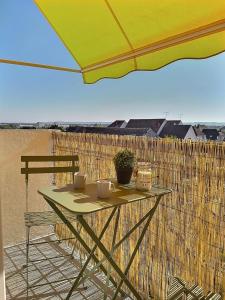 una mesa con dos tazas y una sombrilla en el balcón en Le Voltaire | Balcon | Mon Groom Troyes, en Troyes