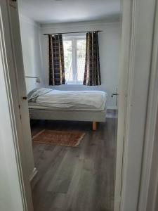 Apartment in Rjukan في Rjukan: غرفة نوم صغيرة بها سرير ونافذة