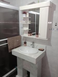 une salle de bain avec un lavabo blanc et un miroir dans l'établissement ALOJAMIENTO TEMPORARIO, à Paso de los Libres