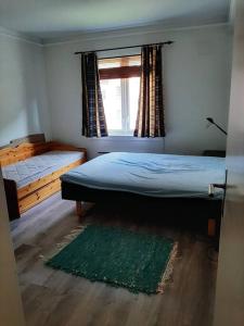 Apartment in Rjukan في Rjukan: غرفة نوم بسرير ونافذة وسجادة