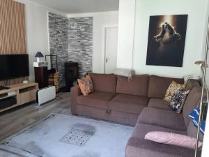 a living room with a brown couch and a tv at Apartment 2 sleeping rooms in Rjukan in Rjukan +2 photos
