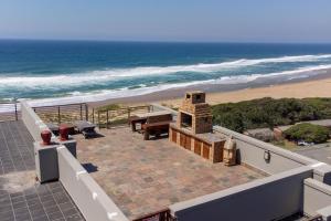 an outdoor patio with a grill and the beach at The Spot on the Beach in Kingsburgh