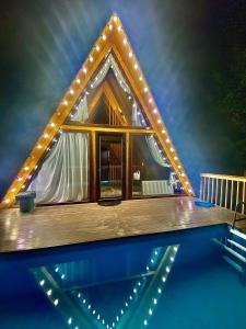 una casa con luci sopra una piscina di Paradise Bungalows - Heated pool a Bum