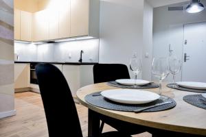 a dining room with a table with chairs and wine glasses at VacationClub - Old Town Apartament 12 in Kłodzko