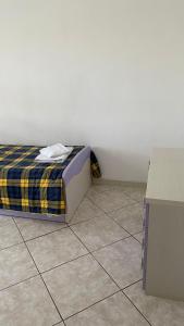 a small bedroom with a bed and a tiled floor at Il villino in Santa Marinella