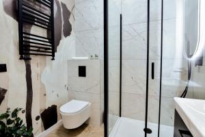 a bathroom with a toilet and a shower at VacationClub - Old Town Apartament 9 in Kłodzko