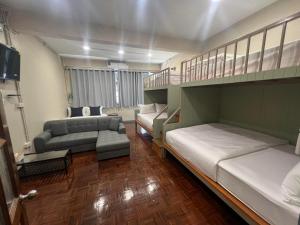 曼谷的住宿－Achcha Family Hotel，一间带两张床和一张沙发的客厅
