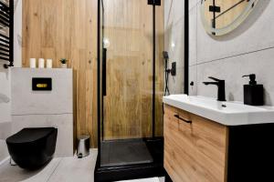 a bathroom with a sink and a shower at VacationClub - Old Town Apartament 1 in Kłodzko