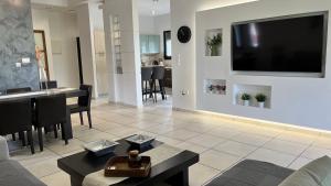 a living room with a flat screen tv on a wall at MaVitaPlace Villa Familia Katerini in Katerini