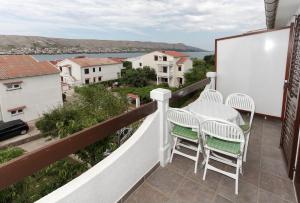 a balcony with a table and chairs and a view at Apartments Spavalo in Pag