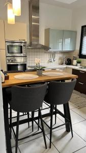 une cuisine avec une table en bois et deux chaises dans l'établissement MaVitaPlace Villa Familia Katerini, à Kateríni