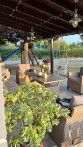 d'une terrasse avec une table, des chaises et une balançoire. dans l'établissement MaVitaPlace Villa Familia Katerini, à Kateríni