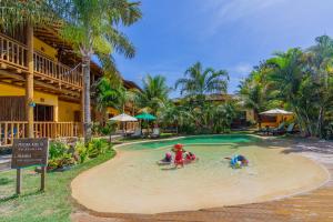 una famiglia che gioca in una piscina in un resort di Pousada Tropicarim a Itacimirim