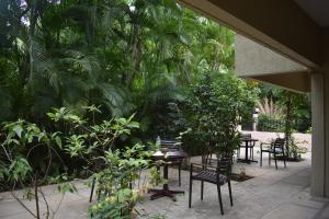 a patio with tables and chairs and plants at Ornate Villa in Pune