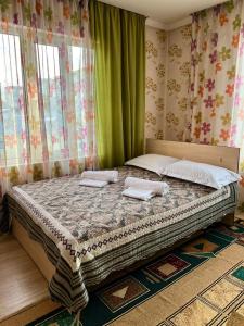 ein Schlafzimmer mit einem Bett mit zwei Kissen darauf in der Unterkunft Гостевой дом Datka in Karakol