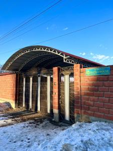 a brick building with an archway on top of it at Гостевой дом Datka in Karakol