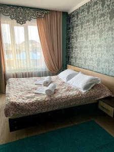 ein Schlafzimmer mit einem Bett mit Handtüchern darauf in der Unterkunft Гостевой дом Datka in Karakol