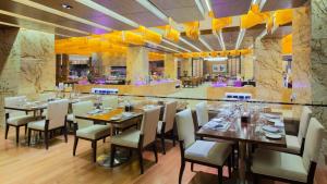 un restaurante con mesas y sillas de madera y un bar en Intercontinental Jinan City Center, an IHG Hotel en Jinan