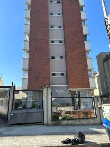 a large brick building with a glass door in front of it at Mi casa Su Casa Apartment Studio 1 a 4 pessoas in Curitiba