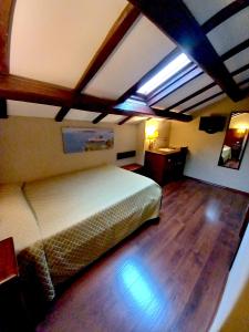 1 dormitorio con 1 cama y suelo de madera en Al Casaletto Hotel, en Settecamini