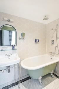 a bathroom with a tub and a sink at The Berkeley Square Hotel Bristol in Bristol