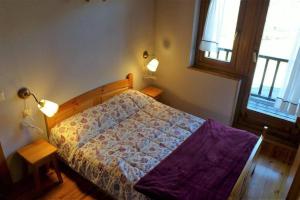 1 dormitorio con 1 cama, 2 lámparas y ventana en Ca La Mimi, en Taüll