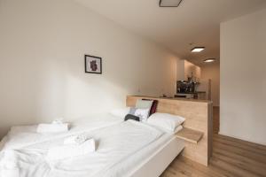 um quarto com uma grande cama branca com almofadas brancas em myQuartier Innsbruck City Apartments em Innsbruck