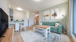 salon z zieloną kanapą i stołem w obiekcie Plac Unii, Sun & Snow w mieście Gdynia
