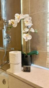 a vase with white flowers on a counter in a bathroom at Best Spacious 1BR at Sky Gardens DIFC in Dubai
