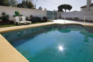 a swimming pool with blue water in a yard at Villa Parra in Chiclana de la Frontera
