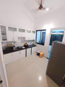 uma grande cozinha com armários brancos e um frigorífico em Casale Majorda em Majorda