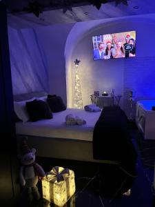 a bedroom with a bed with a tv above it at Suite Vico li cuti in Catania