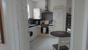 a kitchen with a washer and dryer and a table at Island View in Lymington