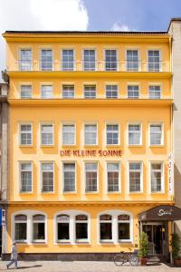 a yellow building with a sign that reads die retrieve some at Hotel die kleine Sonne Rostock in Rostock