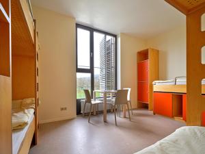 - une chambre avec une table, des chaises et un lit dans l'établissement Youth Hostel Echternach, à Echternach